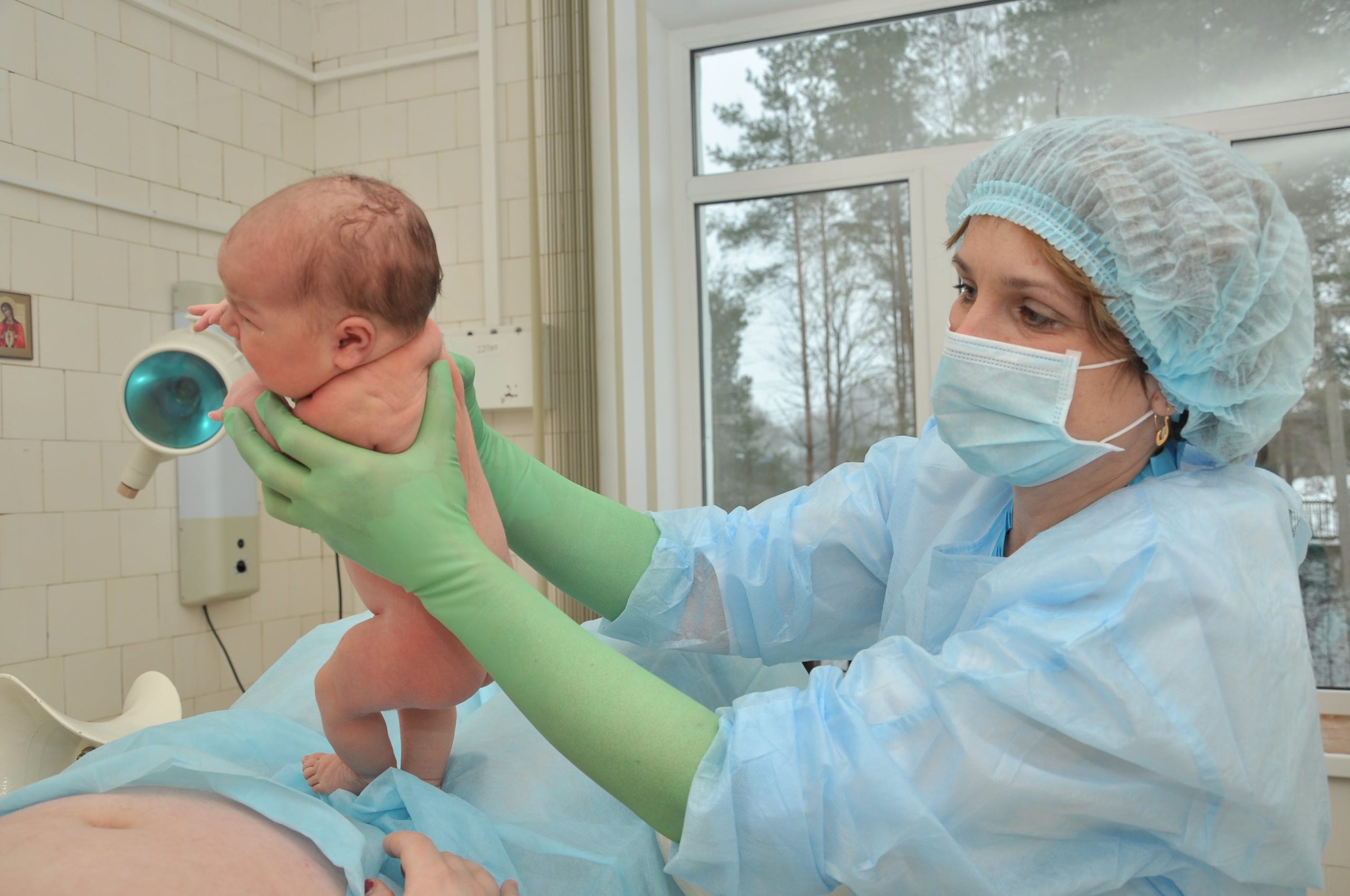 Picture of a newborn held by a healthcare professional