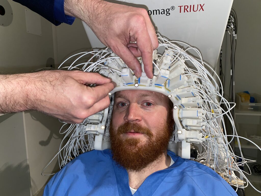 Picture of researcher using brain imaging detector helmet